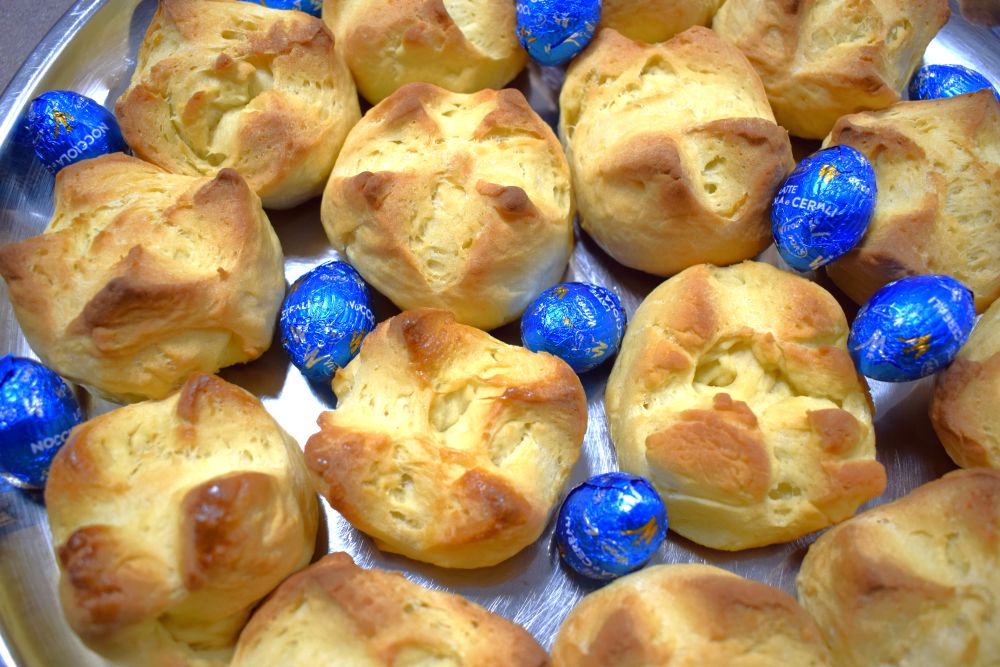 Sladki kruhki in čokoladna jajca v košari.