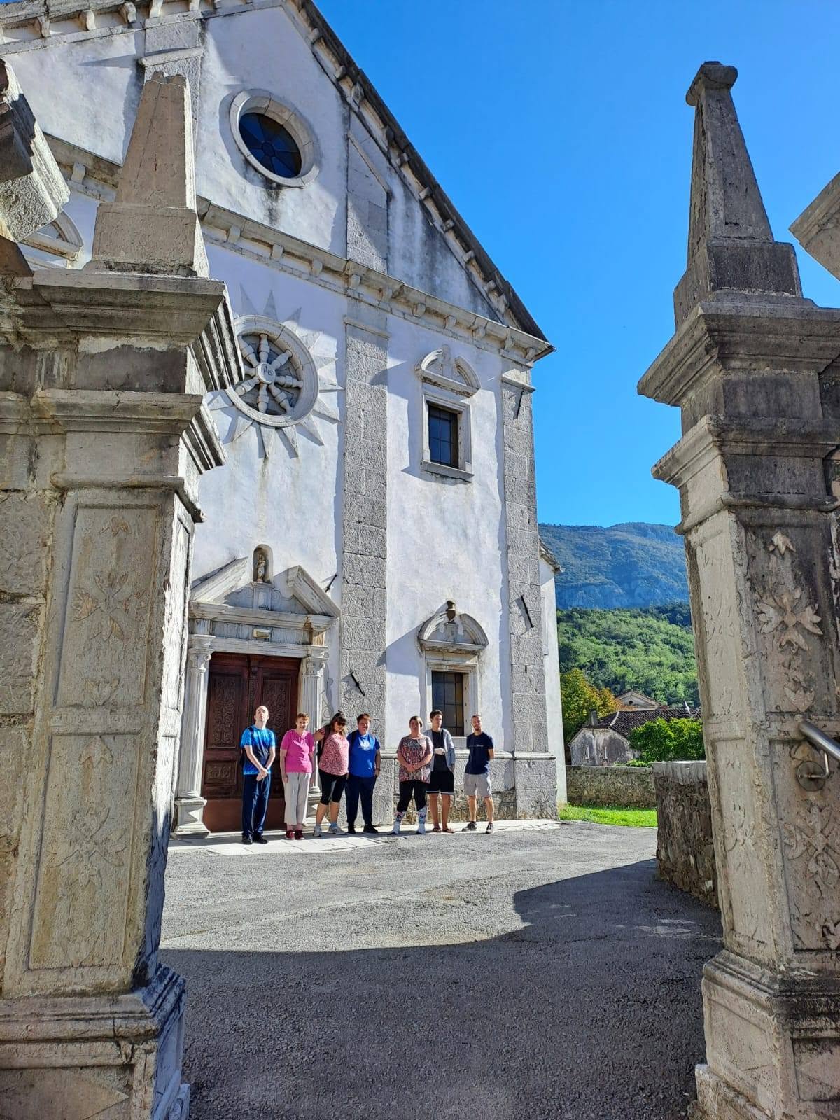 Pohodniška skupina pred cerkvijo v Podnanosu.
